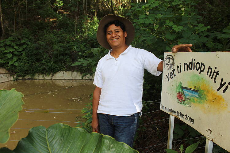  Romeo next to a sign in Zapotec language that reads “this is a dam that harvests rainwater”. WWF is working with Romeo and others in the Copalita-Zimatan-Huatulco landscape in Mexico to protect and restore forests and watersheds. 