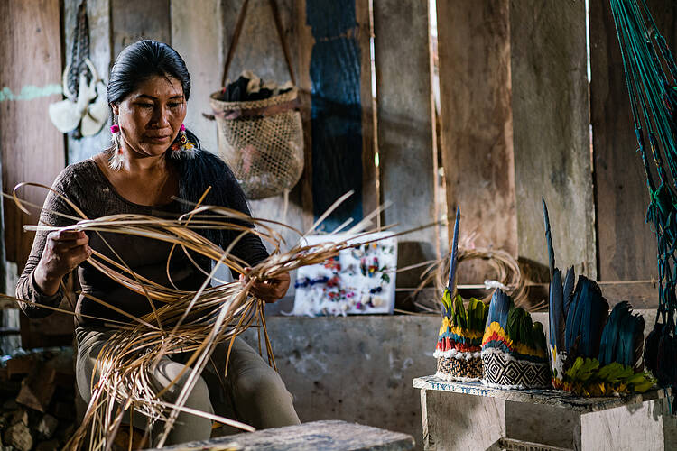  Chela Elena Umire weaves a traditional basket out of palm leaves. 
